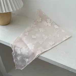 Detailopname van een lichtroze bloemensjaal met geschulpte randen op een tafel