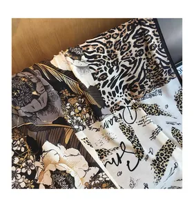 Detail of leopard print and floral patchwork cotton linen scarf on wood surface