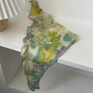 Detail of floral chiffon headscarf with yellow and green abstract flower patterns