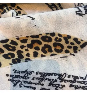 Macro detail of cotton linen scarf showing leopard print and handwritten text texture