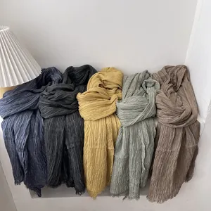 Detail view of cotton linen scarves with pleated texture and fringe in five diverse colors