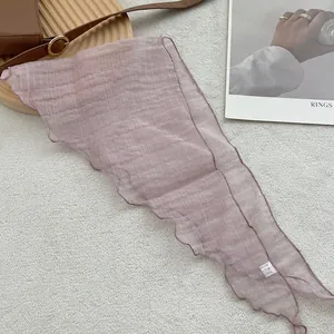 Detail of light purple pleated polyester headscarf with ruffled lettuce edges on grey surface
