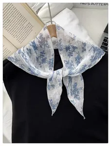 Close-up of vintage blue floral scarf showing the breathable mesh texture on wood hanger