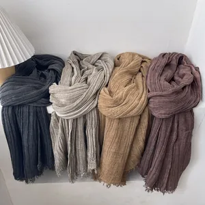 Close-up showing vertical pleated texture and fringed edges of cotton linen scarves