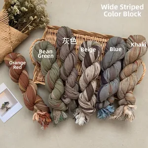 Detail of multi-color striped cotton linen scarves with fringes in a rustic tray