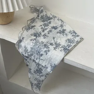 Detail of French vintage floral cotton scarf with blue Toile de Jouy pattern and wavy edges