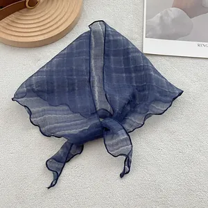 Detail of dark blue linen triangle scarf with wrinkled texture and rolled hem edges