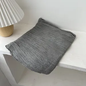 Macro detail of dark grey scarf showing unique pleated texture and soft fabric finish