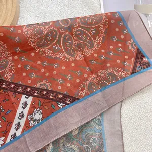 Detail of vintage paisley cotton scarf on white wool background with lifestyle props