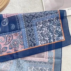 Detail of bohemian paisley cotton linen scarf with fine texture and orange hem finish