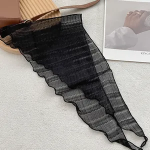 Detail of elegant black pleated mesh scarf showing light translucent texture and fabric folds