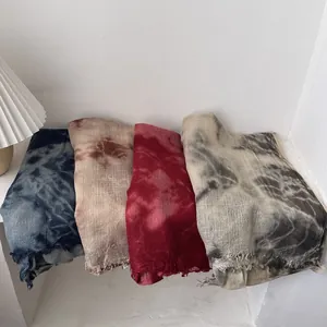 Tie-dye wool scarves with gradient patterns and frayed edges on white background