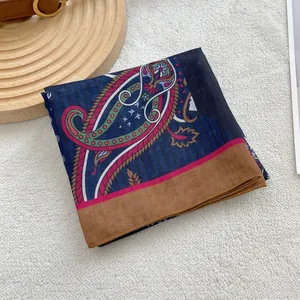 Detail of vintage paisley cotton linen square scarf on a soft textured background