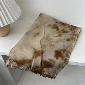Detailed shot of tie-dye wool scarf featuring natural fringe edges and earthy brown tones