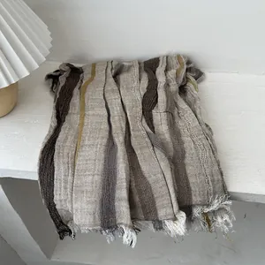 Detailed close-up of retro striped cotton linen scarf with natural fringe edges