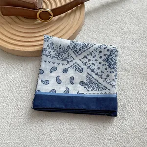Dettaglio del motivo paisley blu navy sulla sciarpa a quadri piegata in legno vivo