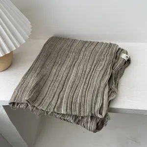 Detailed view of dark beige pleated cotton linen scarf featuring natural fringe edges