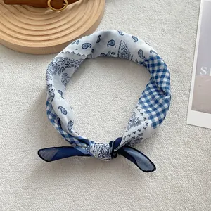Dettaglio della fantasia paisley blu e bianca su un elegante foulard annodato