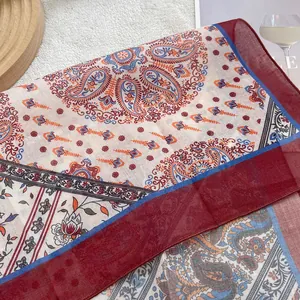 Detail shot of vintage bohemian paisley and floral cotton linen scarf on white background