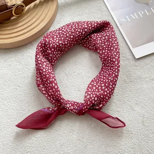 Elegant burgundy silk neck scarf with white polka dots on a minimalist background
