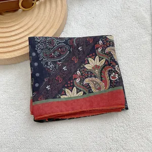 Detail of vintage navy blue paisley cotton linen square scarf with red edges and floral patterns