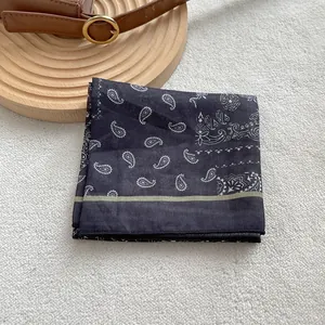 Dettaglio di bandana blu navy con stampa paisley su vassoio in legno e sfondo soffice