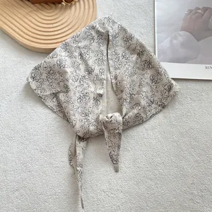 Flat lay of retro floral cotton linen triangle scarf on soft texture background