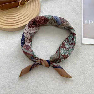 Detail of vintage square silk scarf with floral paisley patterns on a plush background