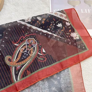 Detail of lightweight paisley and floral cotton linen scarf with rolled hem edges