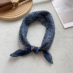 Detail of navy blue polka dot silk scarf on a stylish tray with simple aesthetic