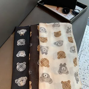 Close-up of lightweight teddy bear scarves in black, brown, and off-white patterns