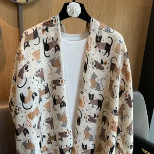 Detail of soft beige cotton linen scarf featuring adorable Nordic style cat illustrations
