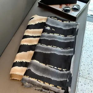 Gros plan d'écharpes à motif léopard avec fils dorés sur un banc texturé