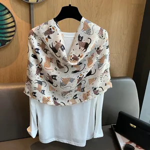 Detail of a beige cotton linen scarf featuring cute cat patterns and a breathable texture