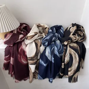 Soft printed scarf with abstract swirl patterns in four colors with fringe edges