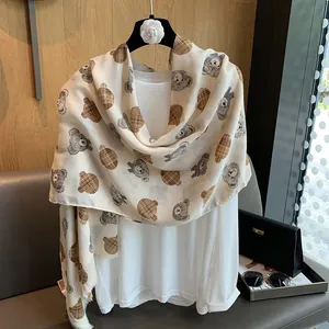 Detail of cotton linen scarf with cartoon teddy bear patterns and frayed fringe edges