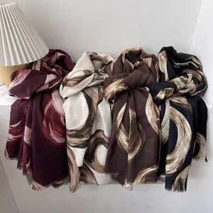 Elegant swirling print scarves in burgundy, cream, brown, and black with raw edges