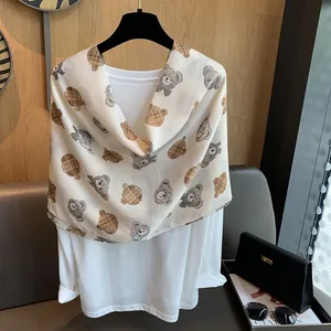 Detail of cartoon teddy bear print on lightweight cotton linen scarf layered on a shirt
