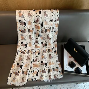 Detail of soft linen shawl with cute dressed cat prints and frayed edge finish
