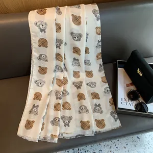 Detail of white cotton linen scarf with teddy bear print and vintage check patterns