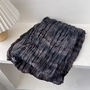 Vue détaillée de l'écharpe en lin plissée avec une texture à motif tie-dye gris foncé