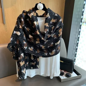 Detail of soft black cotton linen scarf with cute cartoon cat prints and frayed edges