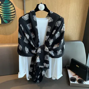 Detail of cartoon teddy bear pattern and grey plaid texture on black cotton linen scarf