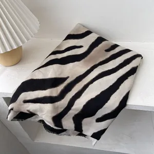 Close-up of zebra pattern scarf showing soft fabric texture and fine fringe details