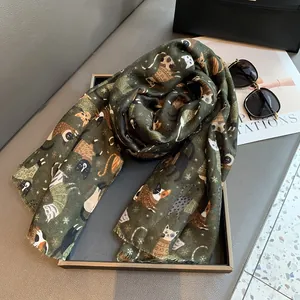 Detailed view of dark green cotton linen scarf featuring colorful cartoon cat patterns