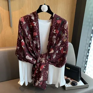 Detail view of burgundy cotton linen scarf featuring cute cat and snowflake patterns