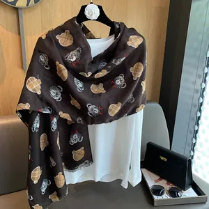 Detailed view of dark brown cotton scarf featuring cute cartoon teddy bear patterns