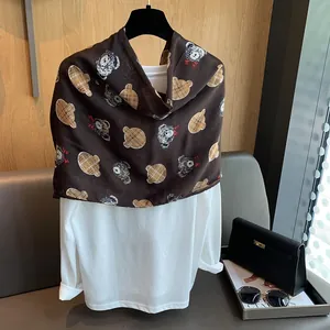Close-up of dark brown cotton scarf featuring cute teddy bear prints on a white shirt