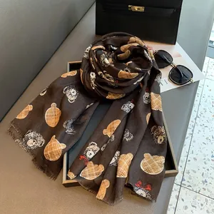 Detail of a dark brown scarf with cartoon bear prints and classic checkered patterns