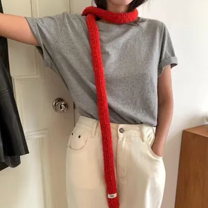 Elegant red knit skinny scarf for women with fringe details and minimalist egg label